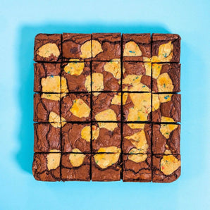 Birthday Brookie by Crumbs & Doilies with chocolate brownie and funfetti cookie dough chunks on blue background.